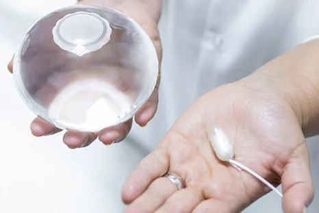 Gastric balloon and swallowable capsule held in a clinician's hands