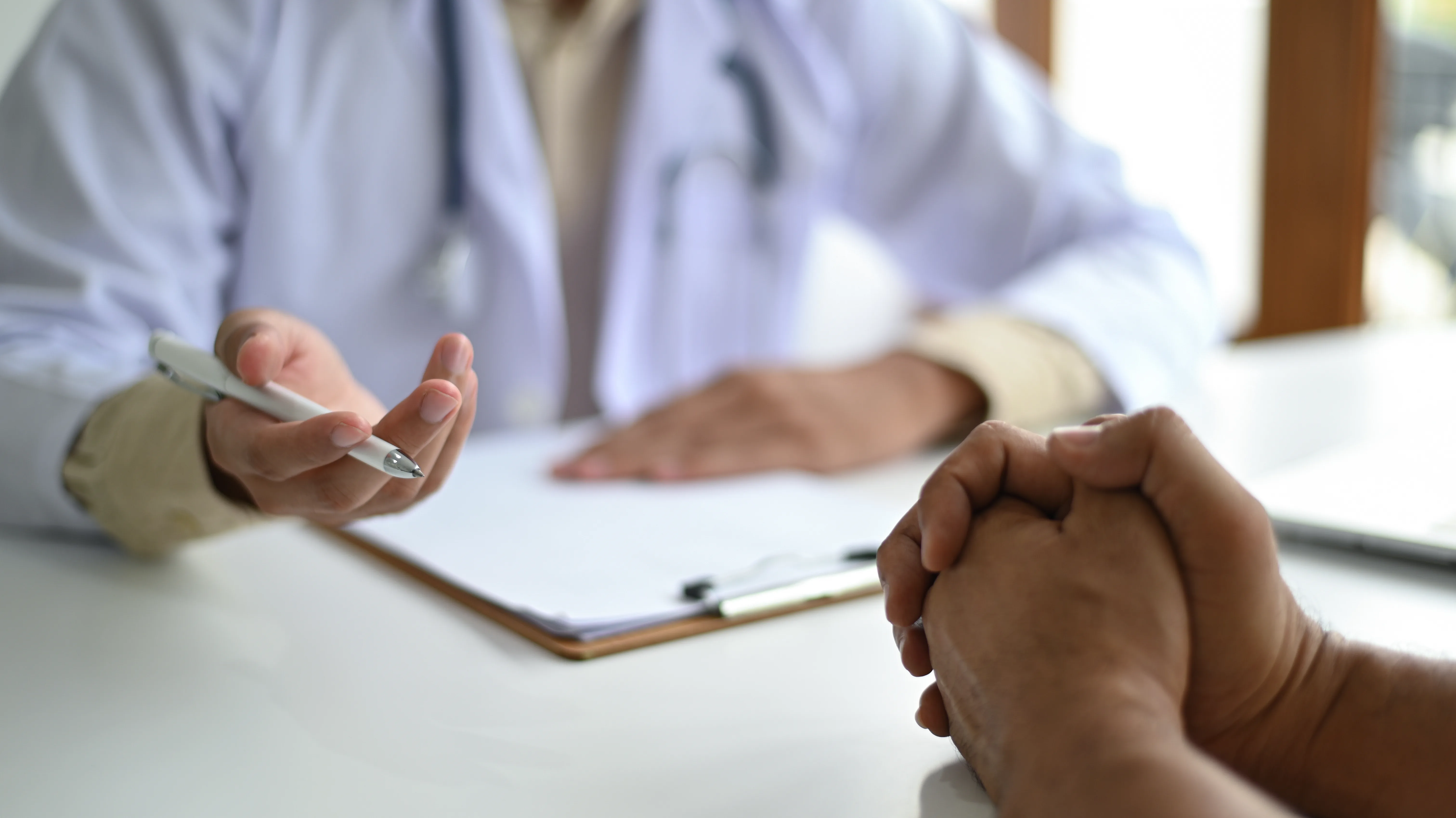 Doctor talking with a patient across a consultation desk